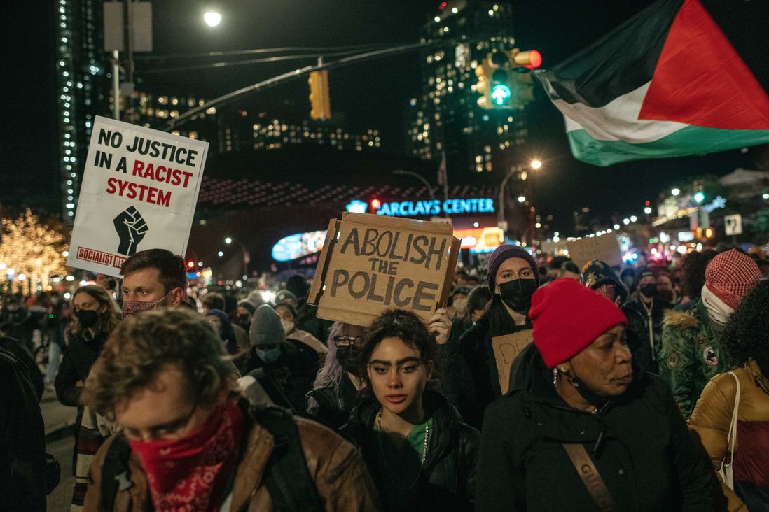 Marchers in a protest against the not guilty verdict in the Kyle Rittenhouse case in Brooklyn on November 19th hold up signs that read "Abolish The Police" and "No Justice Is A Racist System".